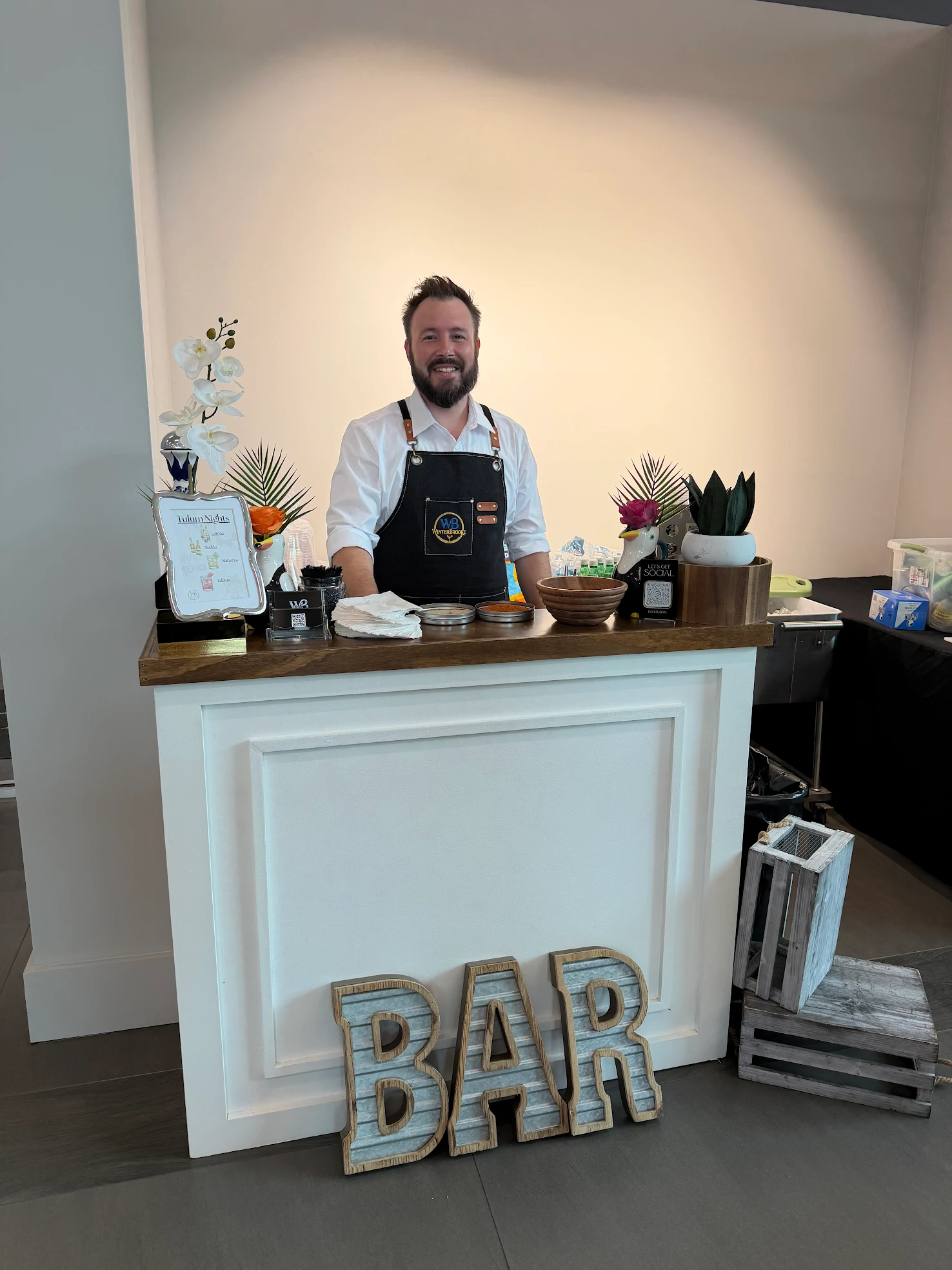 Chris behind the white bar at a UMI Stone showroom event
